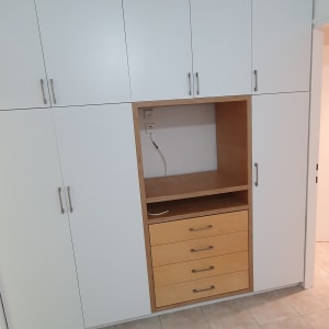 ארון לבן עם ידיות מתכת על רצפת קרמיקה נקייה