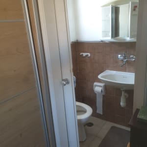 חדר אמבטיה עם כיור וברז, אריחים חומים על הקיר