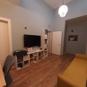 מדף לבן עם ספרים, טלוויזיה ומדפסת בחדר מסודר