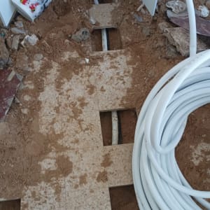 צינורות לבנים על רצפה עם אריחים שבורים