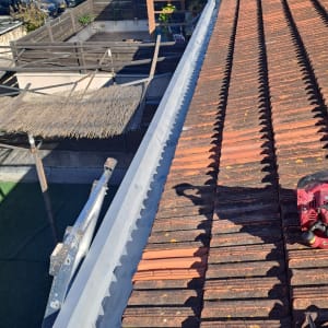 גג רעפים עם מרזב וכלי עבודה על הגג