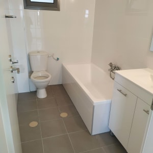 חדר אמבטיה נקי עם אמבטיה, כיור ואסלה