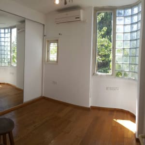 חדר ריק עם רצפת עץ וחלונות זכוכית