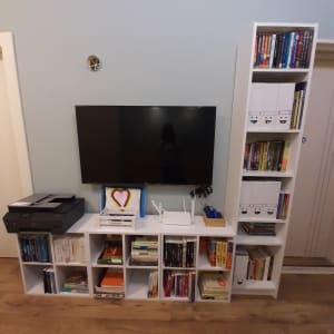 מדפים לבנים עם ספרים, מדפסת וראוטר