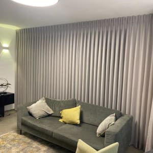 וילון אפור ארוך ומקופל על קיר