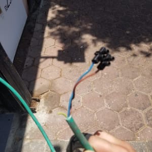 חוטי חשמל חשופים ביד של חשמלאי