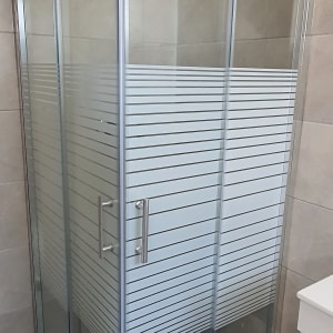 מקלחון זכוכית עם דלתות הזזה וידיות מתכת