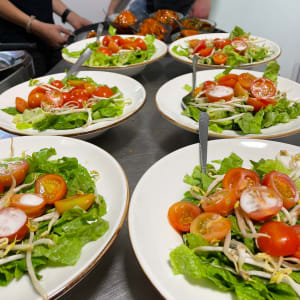 צלחות סלט עם עגבניות, חסה ונבטים על שולחן קייטרינג