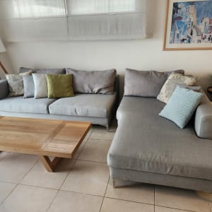 ספות אפורות עם כריות צבעוניות בסלון מואר