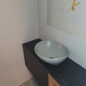 כיור על משטח שיש כהה עם קווים לבנים