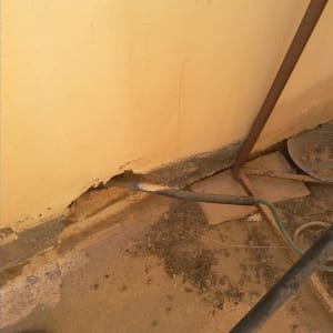 קיר עם סדק, צינור וגושי עפר