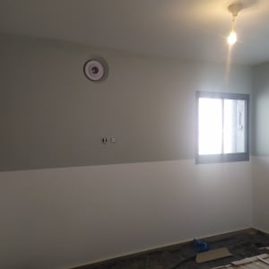 קיר צבוע בשני גוונים עם חלון ותאורה