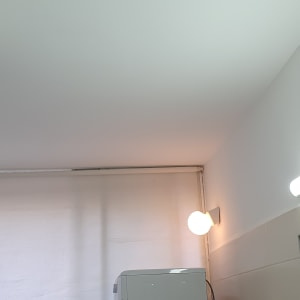 מכונת כביסה ליד קיר עם אריחים ותאורה