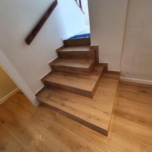 מדרגות עץ נקיות עם מטלית כחולה על הרצפה