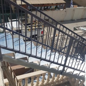 מעקה מתכת על מדרגות חיצוניות עם צל