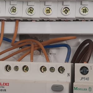 חוטי חשמל מחוברים למפסקי חשמל בלוח חשמל