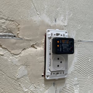 שקע חשמל עם בודק מתח על קיר טיח