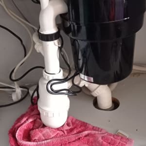 צנרת מתחת לכיור עם מטלית ורודה