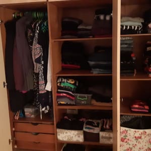 ארון בגדים פתוח עם בגדים מקופלים ומסודרים על מדפים