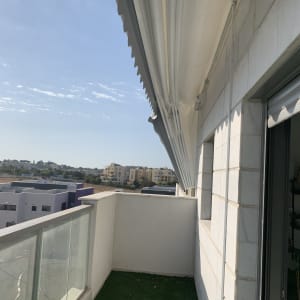 מרפסת עם סוכך לבן פתוח מעליה