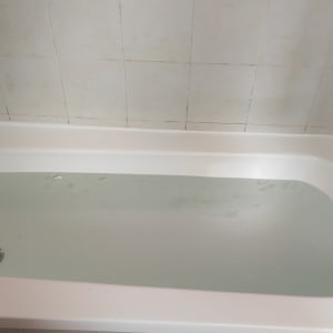 אמבטיה מלאה במים עם ברז מתכת על הקיר