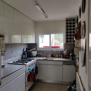 מטבח עם כיריים, כיור, ארונות וכלי מטבח שונים