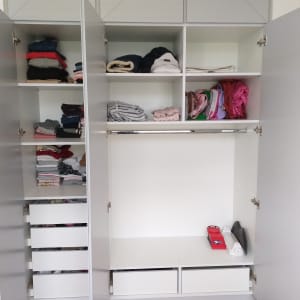 ארון בגדים פתוח עם מדפים ומגירות מסודרים