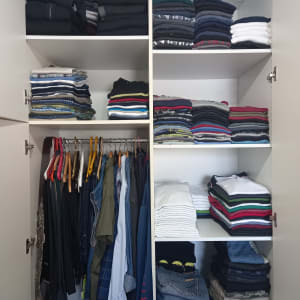 ארון בגדים מסודר עם בגדים מקופלים ותלויים