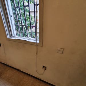 קיר צבוע עם סימני לכלוך ליד חלון פתוח