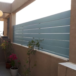 גדר עץ כחולה עם עציצים במרפסת