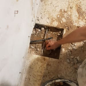 יד מתקנת צינור דולף ברצפה