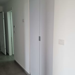 ארון קיר לבן עם דלתות סגורות וידיות מתכת