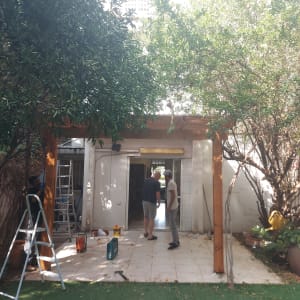 עבודת עץ בגינה עם סולם וכלי עבודה