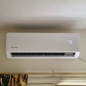 מזגן קיר לבן עם תצוגת טמפרטורה