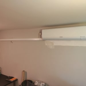 מזגן מותקן על קיר עם צינור חיצוני