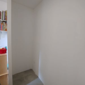 קיר לבן ורצפת אריחים אפורה בפינת שיפוץ