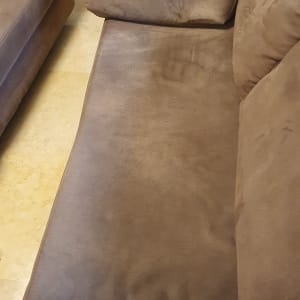 ספה חומה עם כריות על רצפת שיש