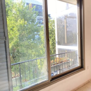 חלון אלומיניום עם מסגרת חומה ומעקה חיצוני