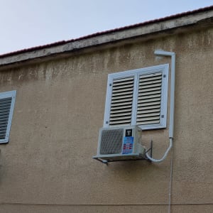 יחידת מיזוג אוויר מותקנת על קיר חיצוני