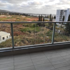 מרפסת עם רצפה נקייה ומעקה זכוכית