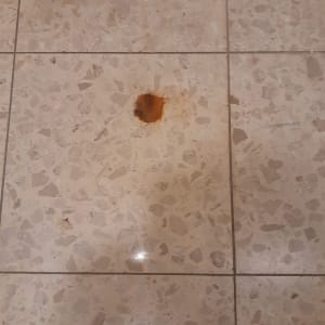 כתם חלודה על רצפת אריחים בהירה