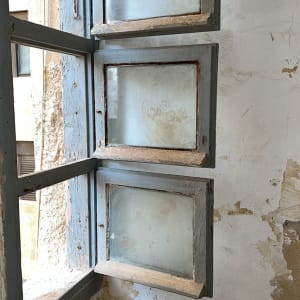 חלונות זכוכית ישנים עם מסגרות עץ מתקלפות