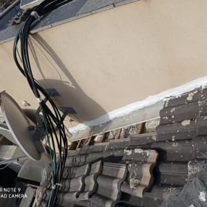 צלחת לוויין וכבלים על גג רעפים עם תיקונים