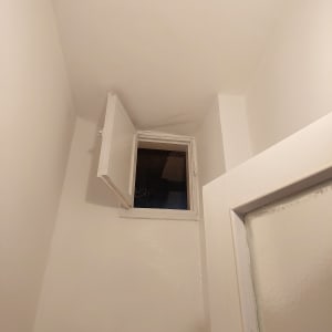 קירות ותקרה צבועים בלבן עם חלון פתוח
