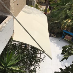 סוכך לבן מחובר לקיר עם תמיכה מתכתית