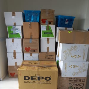 קופסאות קרטון ופלסטיק מסודרות בערימה בחדר