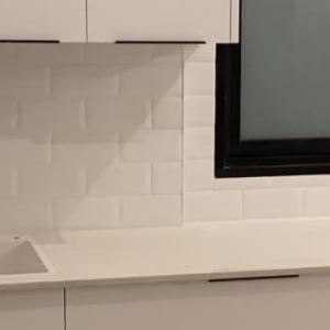 מטבח בשיפוץ עם ארונות לבנים וכיור מותקן