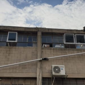 חלונות עם תריסים פתוחים בבניין תעשייתי