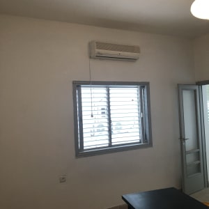 קיר לבן עם חלון ומזגן