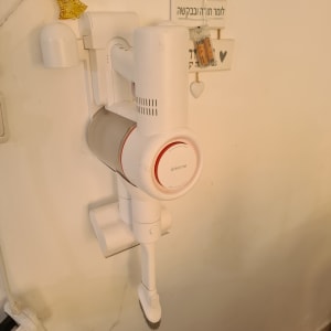 שואב אבק ידני תלוי על הקיר עם מטען